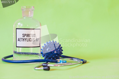 Image of Ethanol in a bottle on the table with of microscope virus close up and stethoscope, Coronavirus concept Tablet in the fingers of hand