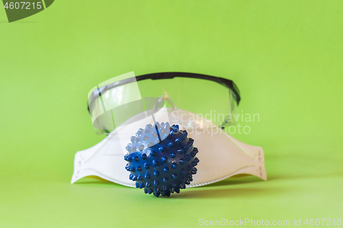 Image of Protecting mask and glasses on the table and microscope virus close up,. Coronavirus concept Tablet in the fingers of hand