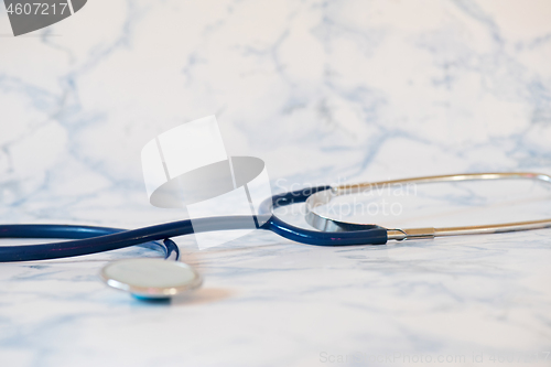 Image of Medical stethoscope or phonendoscope over light blue background Tablet in the fingers of hand