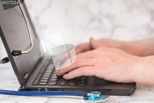 Image of Stethoscope and notebook Tablet in the fingers of hand