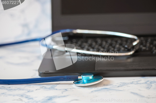 Image of Stethoscope and notebook Tablet in the fingers of hand