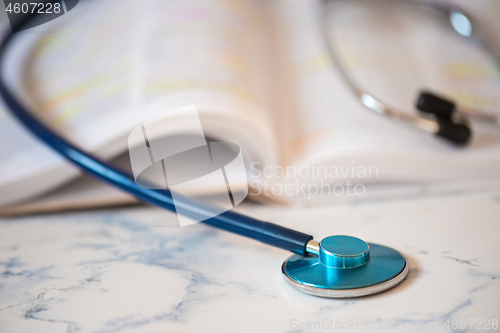 Image of Stethoscope and book Tablet in the fingers of hand