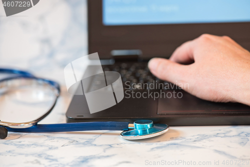 Image of Stethoscope and notebook Tablet in the fingers of hand