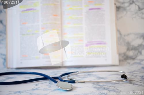 Image of Stethoscope and book Tablet in the fingers of hand