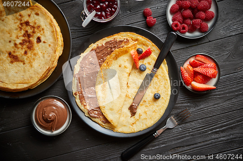 Image of Delicious chocolate homemade pancakes on black ceramic plate