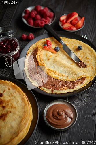 Image of Delicious chocolate homemade pancakes on black ceramic plate