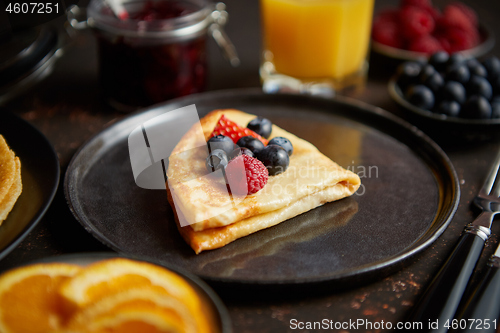 Image of Tasety homemade pancake on black ceramic plate.