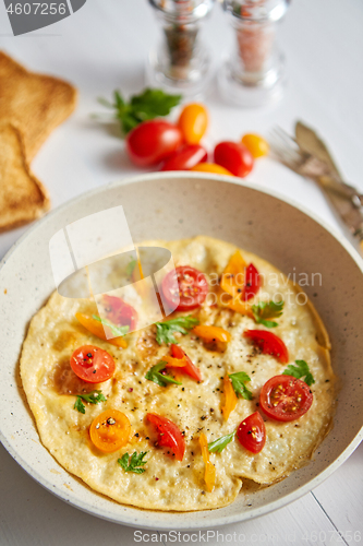 Image of Tasty homemade classic omelet with cherry tomatoes