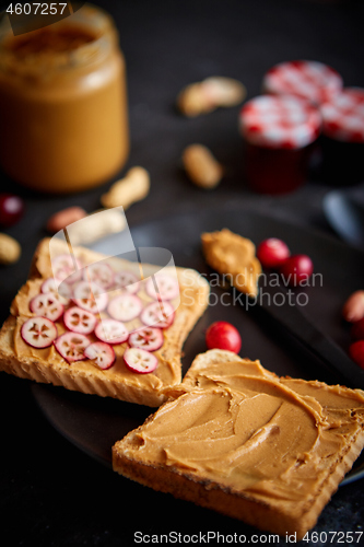 Image of Toasts bread with homemade peanut butter served with fresh slices of cranberries