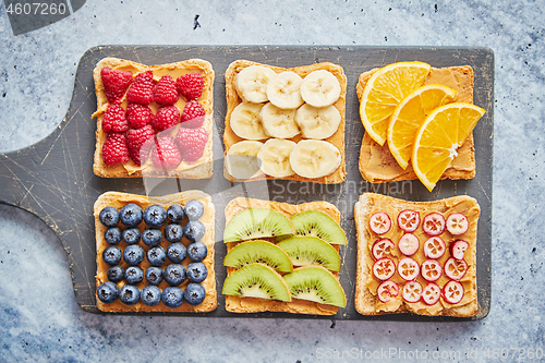 Image of Wholegrain bread slices with peanut butter and various fruits