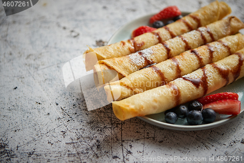 Image of Plate of delicious crepes roll with fresh fruits and chocolate