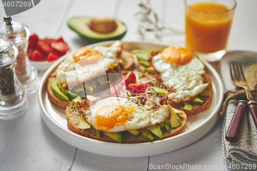 Image of Delicious healthy breakfast with sliced avocado sandwiches with fried egg