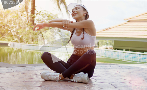 Image of Cheerful female stretching arms during swimming pool