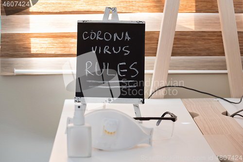 Image of Conceptual photo with miniature blackboard, protecting mask and antiseptic. Stay home concept