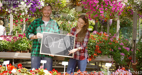 Image of Two florists with open sign in their shop