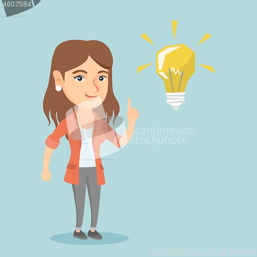 Image of Young caucasian student pointing at idea lightbulb