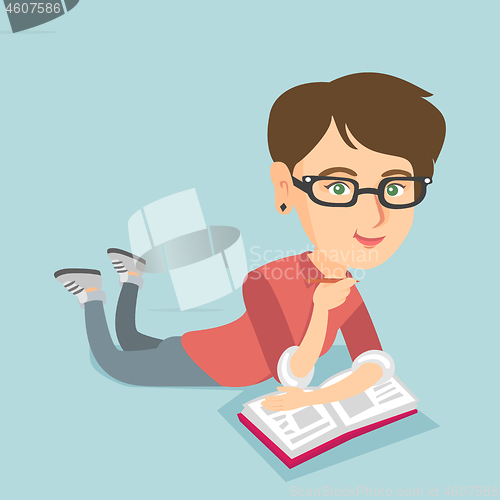 Image of Student laying on the floor and reading a book.