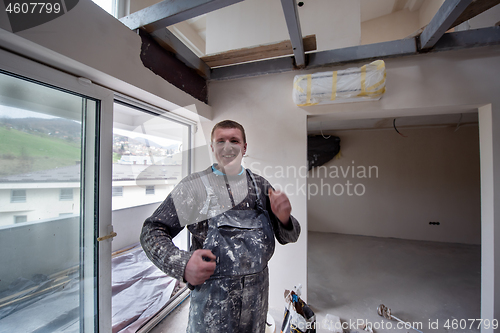 Image of portrait of construction worker with dirty uniform in apartment