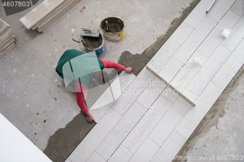 Image of worker installing the ceramic wood effect tiles on the floor