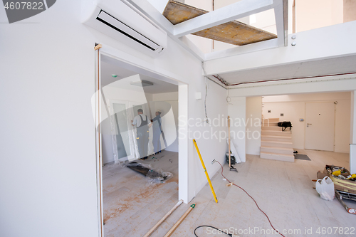 Image of carpenters installing glass door with a wooden frame