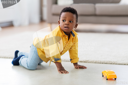 Image of african american baby boy playing with toy car