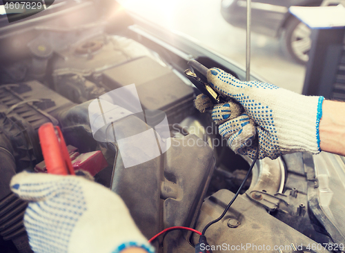 Image of auto mechanic man with cleats charging battery