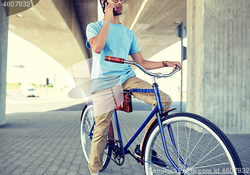 Image of man with smartphone and fixed gear bike on street