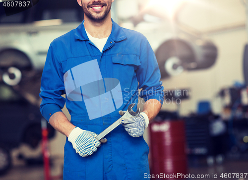 Image of auto mechanic or smith with wrench at car workshop