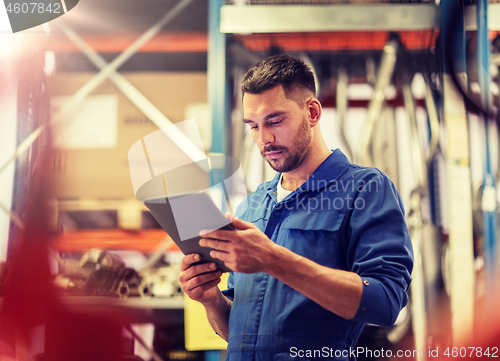 Image of auto mechanic or smith with tablet pc at workshop