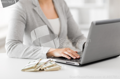 Image of close up of businesswoman with laptop and money