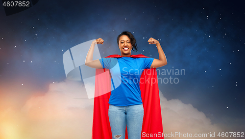 Image of happy african american woman in superhero red cape