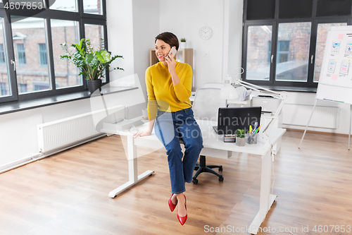 Image of happy woman and calling on smartphone at office