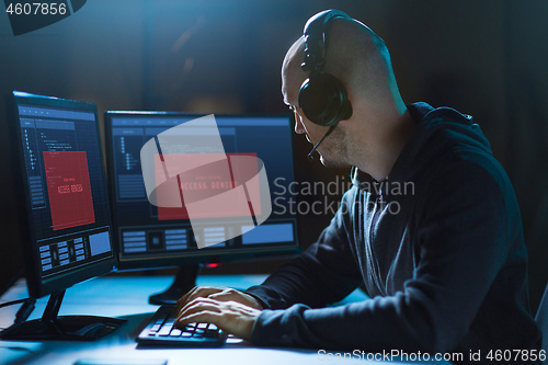 Image of hacker with access denied messages on computers