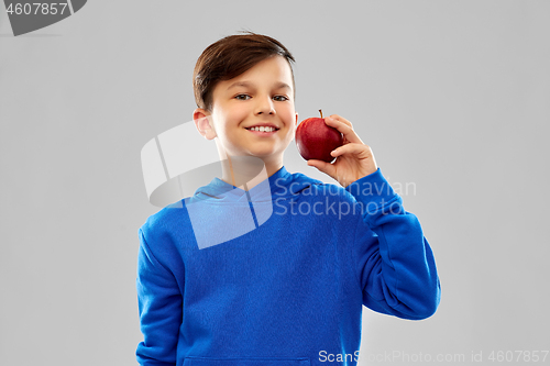 Image of smiling boy in blue hoodie with red apple