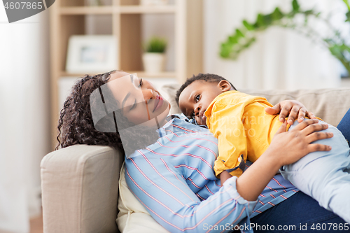 Image of happy african american mother with baby at home