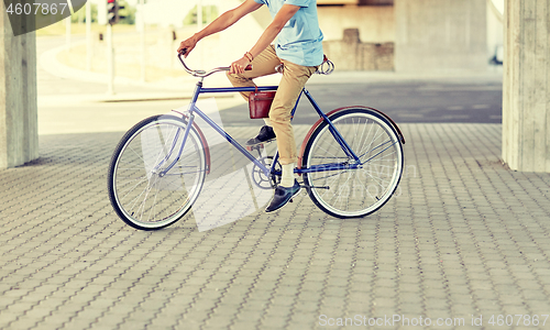 Image of hipster man riding fixed gear bike
