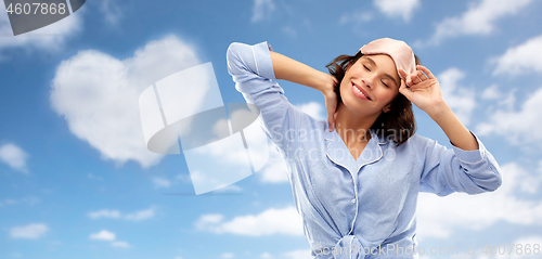 Image of happy young woman in pajama and eye sleeping mask