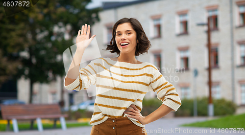 Image of smiling woman or student girl waving hand
