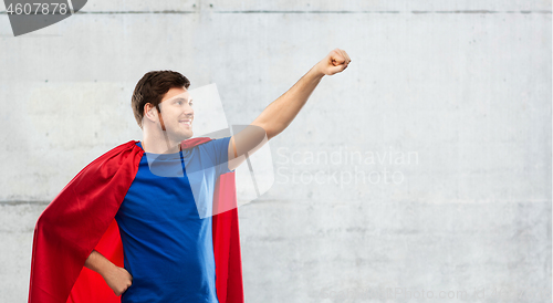 Image of man in red superhero cape over concrete background