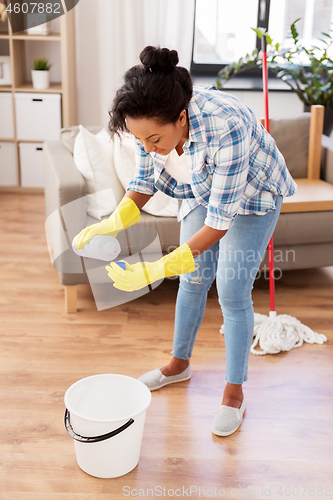 Image of african woman or housewife cleaning floor at home