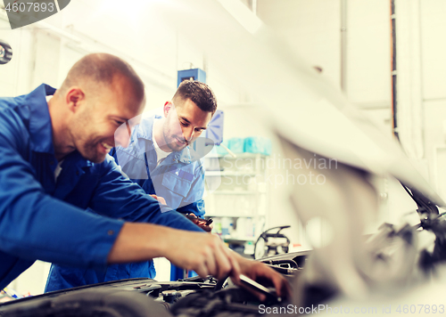 Image of mechanic men with wrench repairing car at workshop