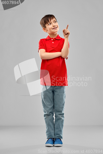 Image of little boy in red polo t-shirt pointing finger up