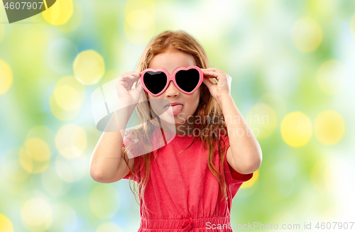 Image of naughty red haired girl in heart shaped sunglasses