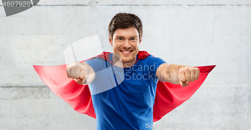 Image of man in red superhero cape over concrete background