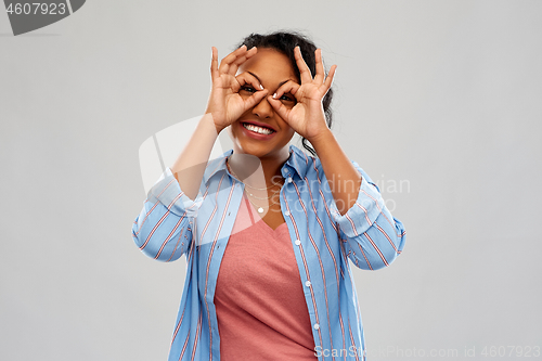 Image of african woman looking through finger glasses