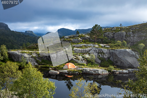 Image of Tourist tent on the shore of a lake in the mountains. Beautiful 