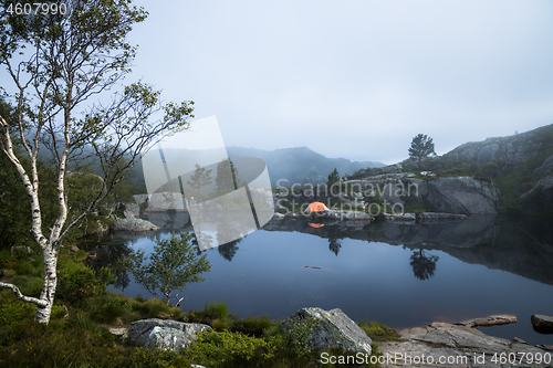 Image of Tourist tent on the shore of a lake in the mountains. Beautiful 