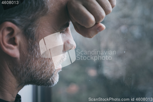 Image of portrait one sad man standing near a window