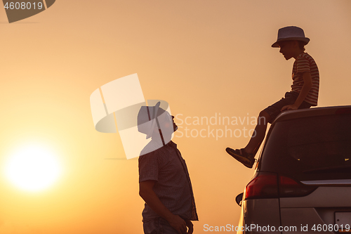 Image of Father and son playing in the park at the sunset time.