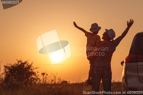 Image of Father and son playing in the park at the sunset time.